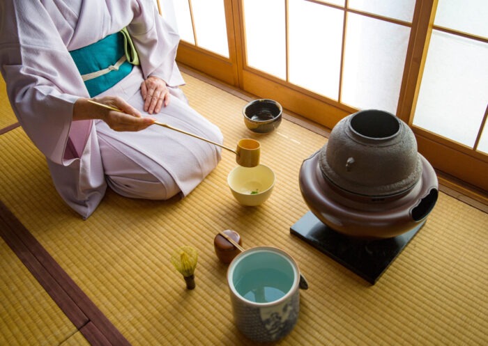 Cerimónia do chá em viagem ao japão com senhora japonesa vestida com kimono cor-de-rosa que serve chá