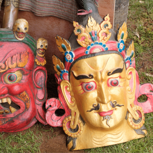 Duas máscaras tradicionais Budistas, uma doirada e uma vermelha, na viagem ao Butão