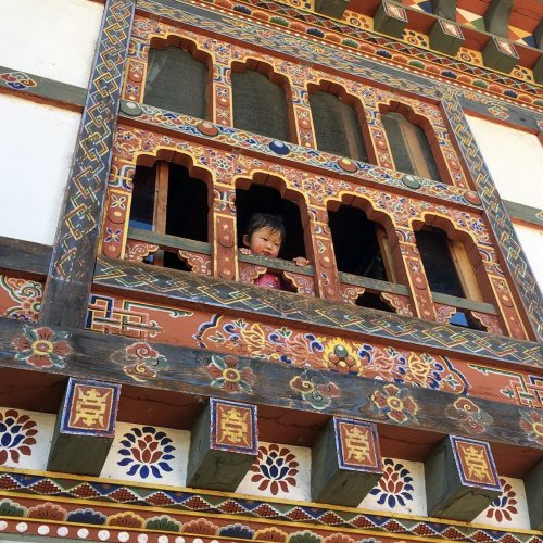 Criança na varanda de uma casa de uma aldeia no Butão na Viagem Nepal e Butão