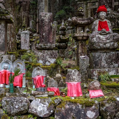 Várias estátuas de pedra de Jizo com babetes vermelhas