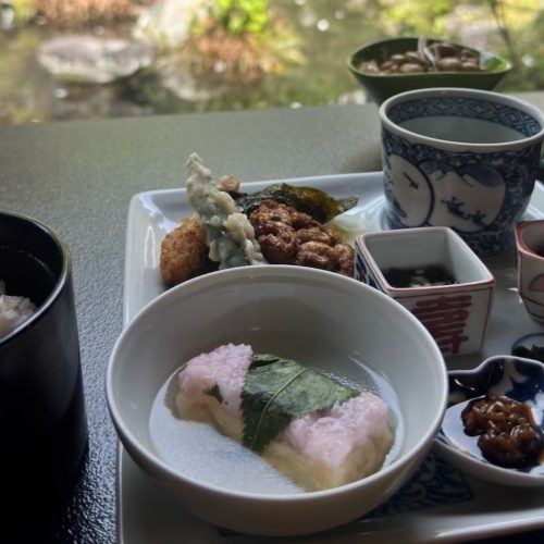 Pequenos pratos com comida japonesa e uma vista para a natureza