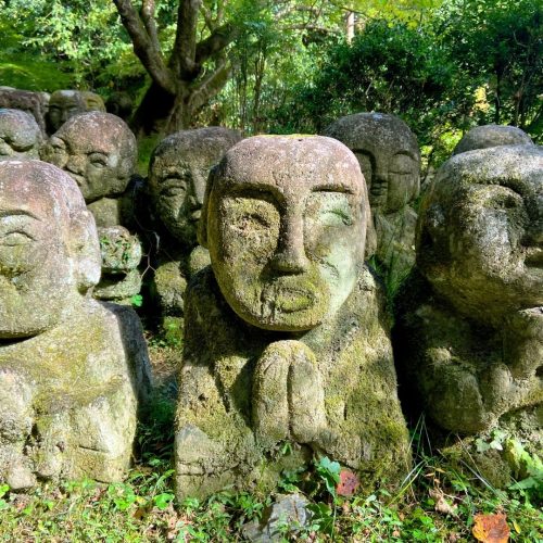 Estátuas com musgo típicas japonesas num ambiente natural com árvores e natureza