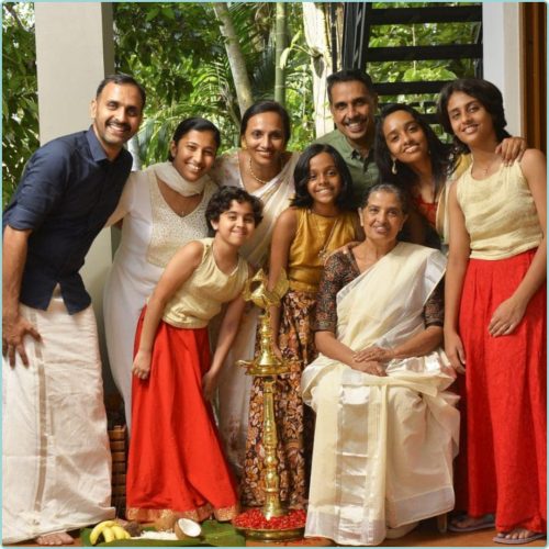 Família Madukkakuzhy sorridente numa foto de grupo com a avó, netos, filhos e noras