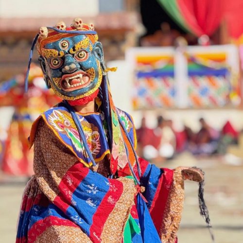 Dança cham com um monge vestido com as máscaras e roupas tradicionais desta dança que acontece nos festivais, no Butão.