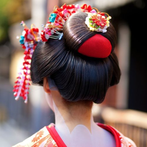 Geisha de coostas, v~e-se os detalhes do penteado e o pescoço