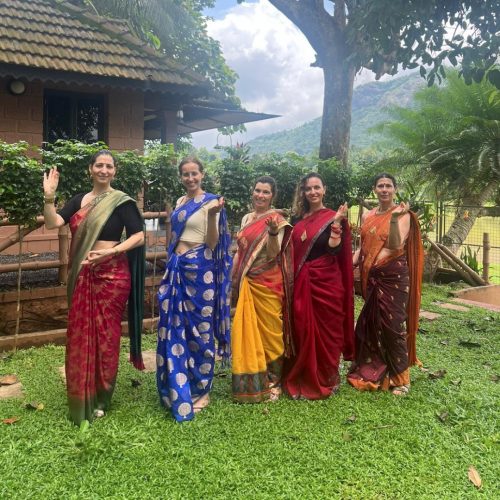 Cinco mulheres portuguesas vestidas com sarees coloridos no centro Madukkakuzhy Ayurveda