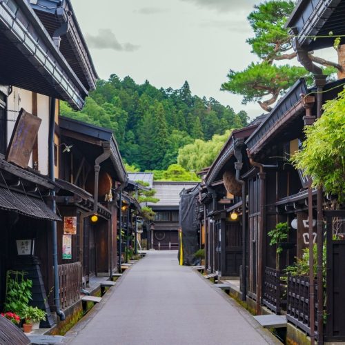 Rua tradicional de Kyoto, com casas de madeira e muitas árvores muito verdes