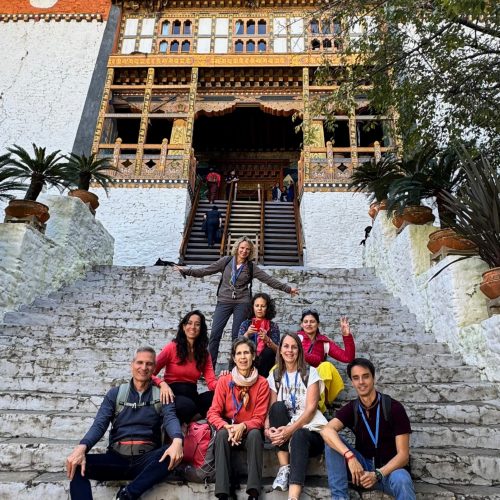 Grupo sentado numas escadas que dão para o Punaka Dzong