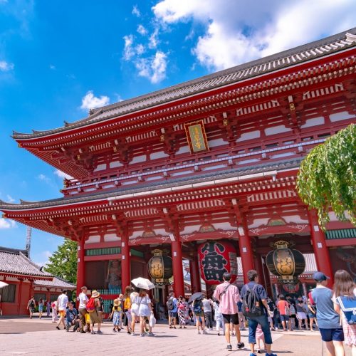Turistas a entrarem para um templo vermelho no japão